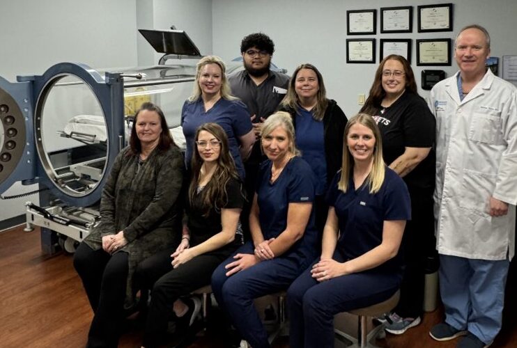 Photo of the Newman Regional Health Wound Care Team with HBOT Chamber in the background